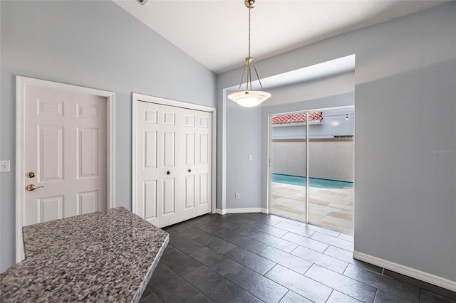 unfurnished dining area with vaulted ceiling