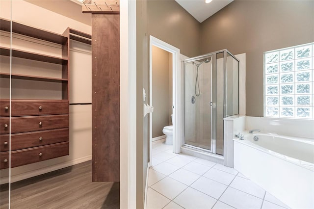 bathroom with separate shower and tub, hardwood / wood-style floors, and toilet