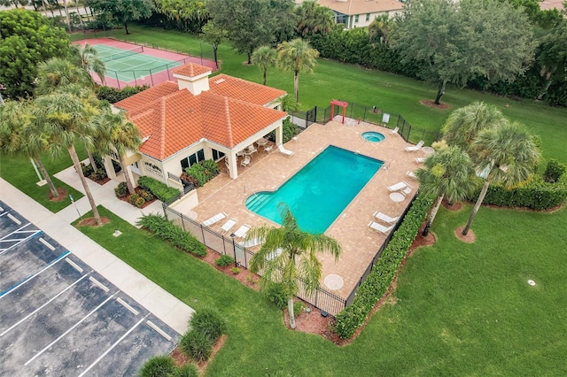 view of swimming pool featuring a lawn and tennis court