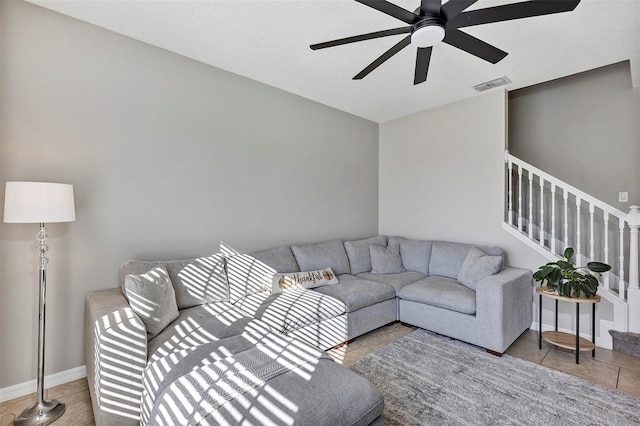 living room with ceiling fan, light tile patterned floors, and a textured ceiling