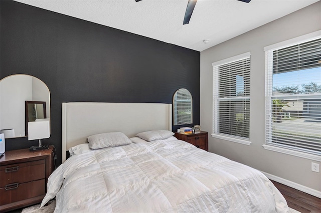 bedroom with a textured ceiling, dark hardwood / wood-style floors, and ceiling fan