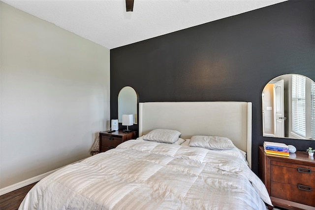 bedroom with hardwood / wood-style flooring, ceiling fan, and vaulted ceiling