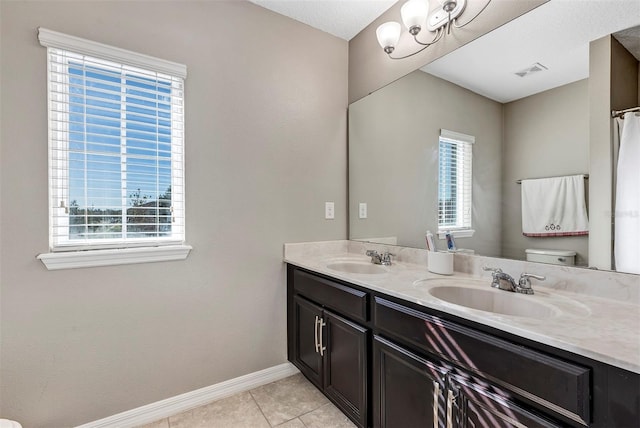 bathroom with tile patterned flooring, vanity, toilet, and a wealth of natural light