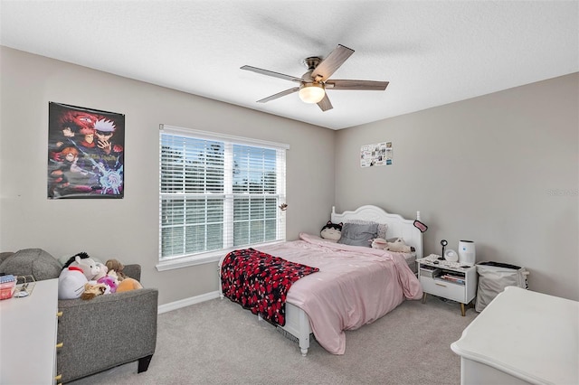 bedroom with ceiling fan, light carpet, and a textured ceiling