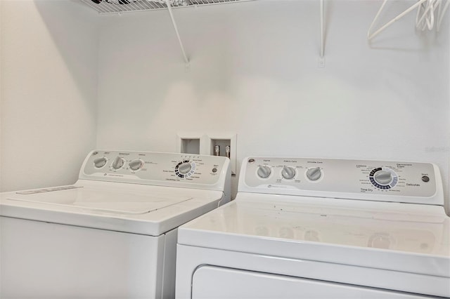 clothes washing area with washer and clothes dryer