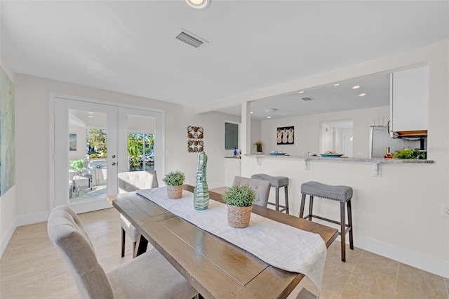 tiled dining space featuring french doors