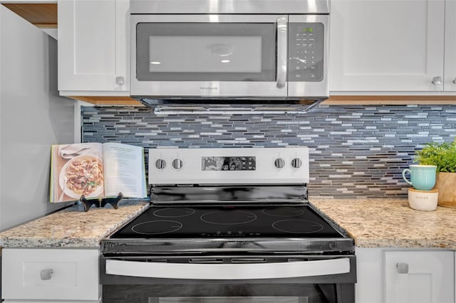 kitchen with white cabinets, decorative backsplash, light stone countertops, and appliances with stainless steel finishes