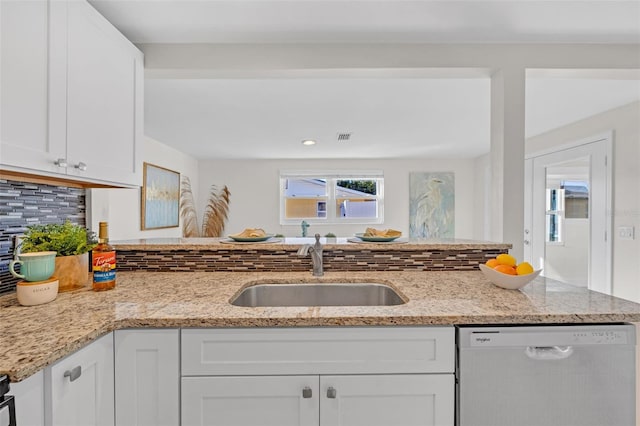 kitchen with dishwasher, decorative backsplash, white cabinets, and sink