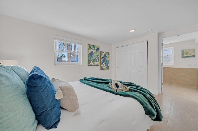 tiled bedroom with a closet and multiple windows