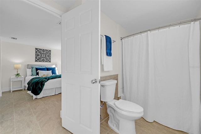 bathroom featuring tile patterned floors, toilet, and a shower with shower curtain