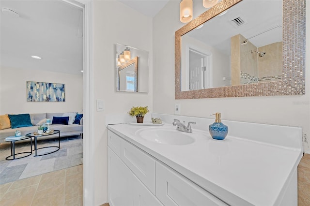 bathroom with tile patterned floors, vanity, and tiled shower