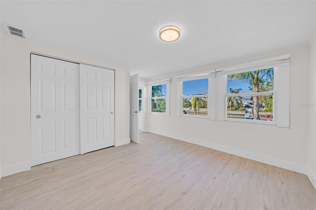 unfurnished bedroom with light hardwood / wood-style floors and a closet