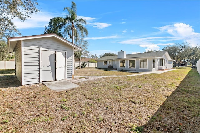 back of property featuring a lawn and a shed