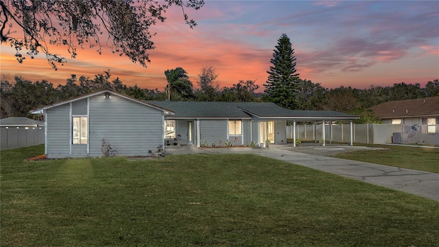 ranch-style house featuring a carport, cooling unit, and a yard