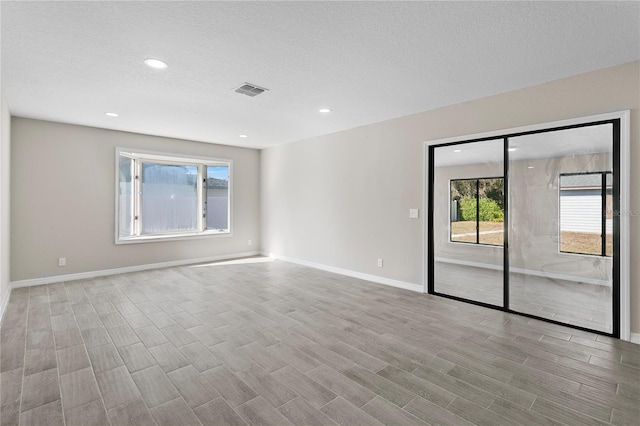 unfurnished room with a textured ceiling