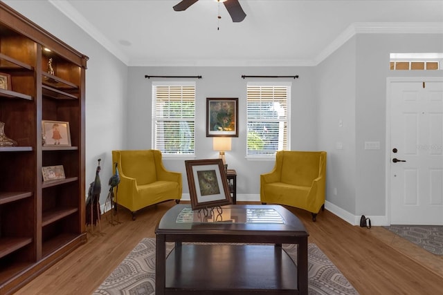 living area with crown molding, ceiling fan, and wood-type flooring