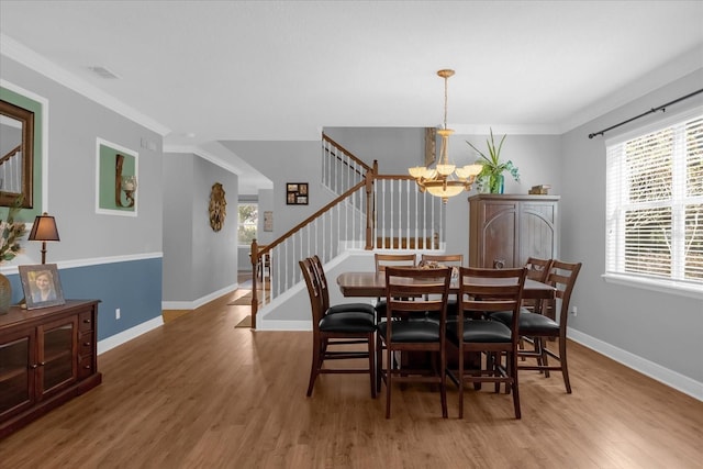 dining space featuring hardwood / wood-style flooring, a healthy amount of sunlight, and ornamental molding