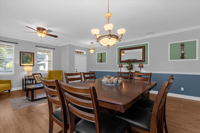 dining area with crown molding, hardwood / wood-style floors, and ceiling fan with notable chandelier