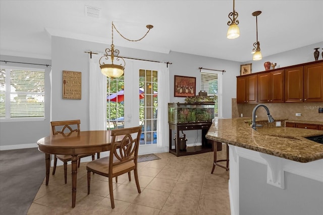 dining space with light tile patterned floors, french doors, and sink