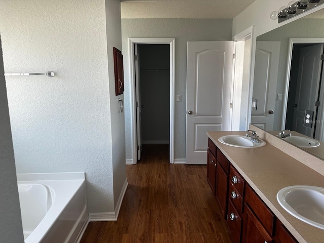 bathroom featuring vanity, a bathtub, and wood-type flooring