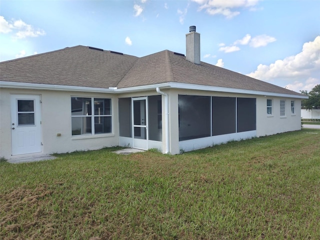 back of property featuring a sunroom and a yard