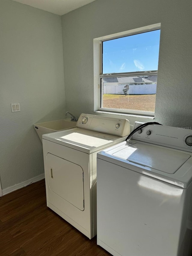 washroom with separate washer and dryer, dark hardwood / wood-style floors, and sink