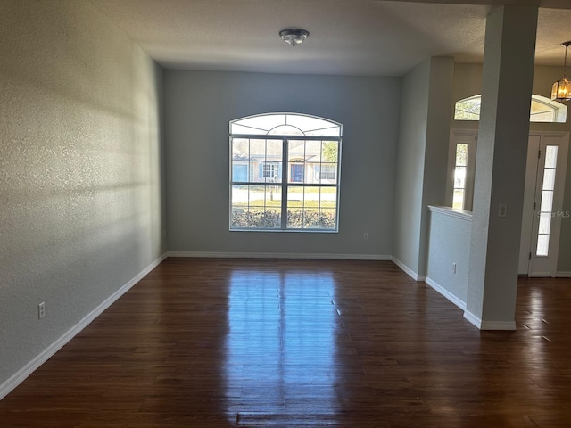 interior space with a notable chandelier and dark wood-type flooring