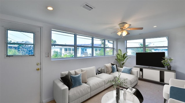 living room featuring a wealth of natural light and ceiling fan