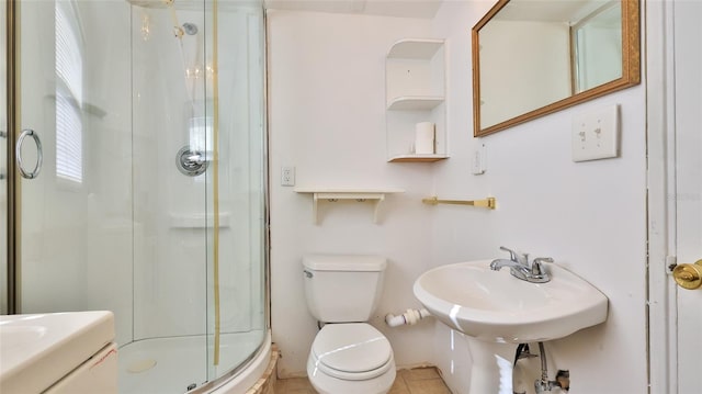 bathroom featuring tile patterned floors, toilet, and a shower with shower door