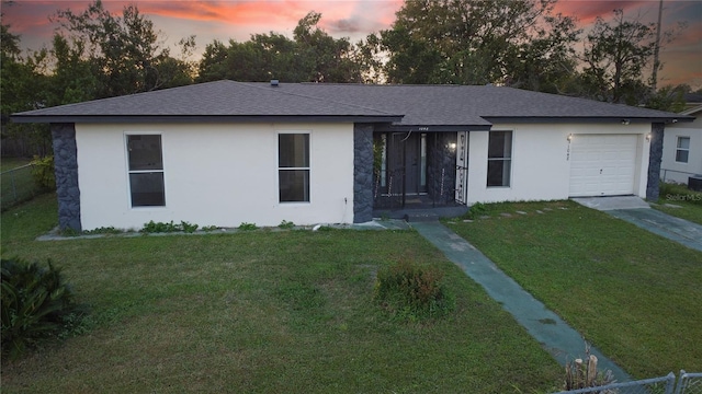 ranch-style house featuring a lawn and a garage