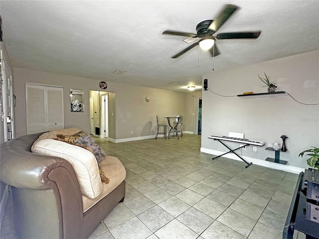 tiled living room featuring ceiling fan and a textured ceiling