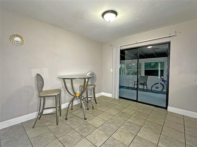 dining space with light tile patterned floors and a textured ceiling