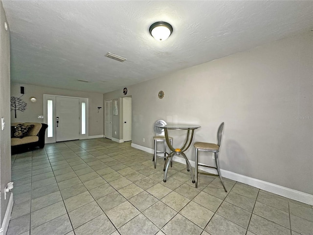 tiled dining area featuring a textured ceiling