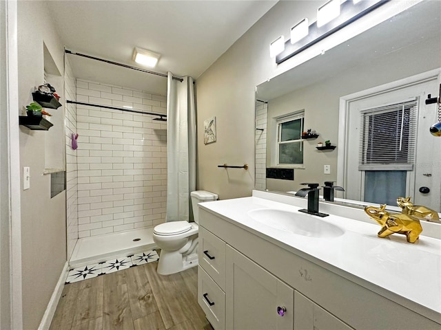 bathroom featuring a shower with shower curtain, hardwood / wood-style floors, vanity, and toilet