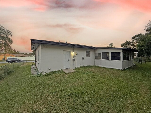 back house at dusk with a yard