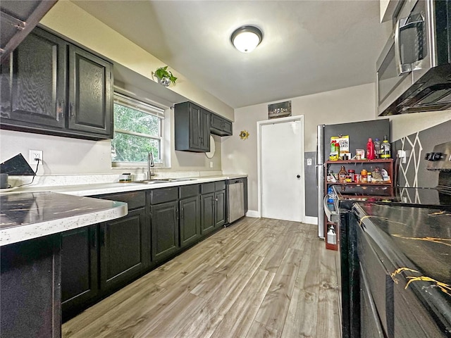 1048 Wakefield Cir, Deltona, FL 32725 - kitchen featuring appliances with stainless steel finishes, light wood-type flooring, and dark cabinetry