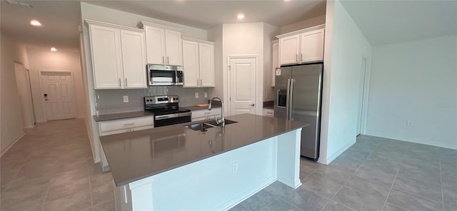 kitchen with white cabinets, an island with sink, stainless steel appliances, and sink