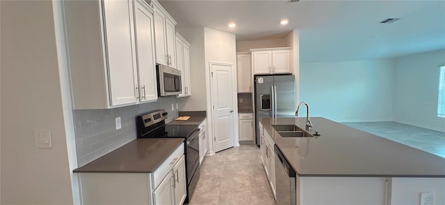 kitchen featuring white cabinetry, sink, decorative backsplash, light tile patterned floors, and appliances with stainless steel finishes