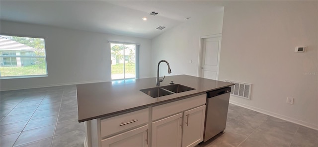 kitchen featuring dishwasher, a kitchen island with sink, sink, vaulted ceiling, and white cabinetry