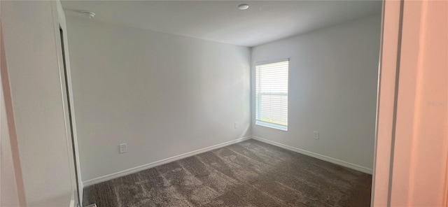 empty room with dark colored carpet