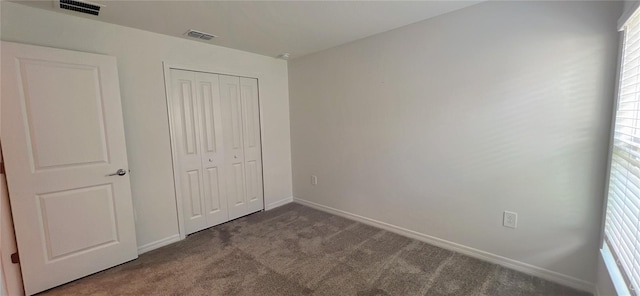 unfurnished bedroom featuring multiple windows, a closet, and carpet