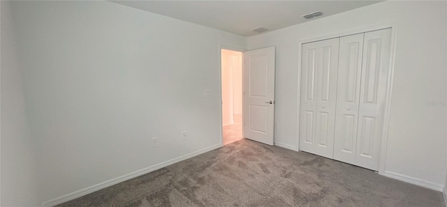 unfurnished bedroom with carpet flooring and a closet