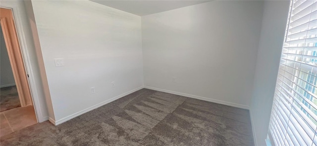 spare room featuring dark carpet