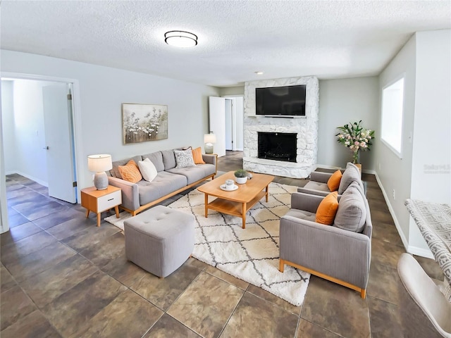 living room with a stone fireplace and a textured ceiling