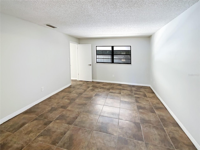 unfurnished room with a textured ceiling