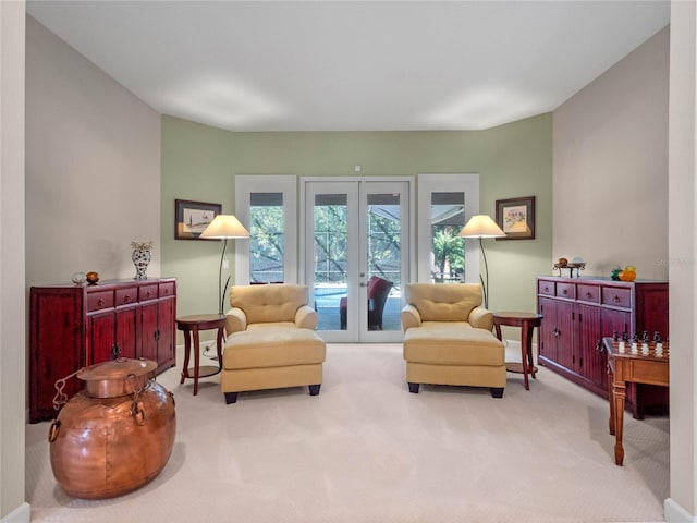 sitting room with french doors and light colored carpet