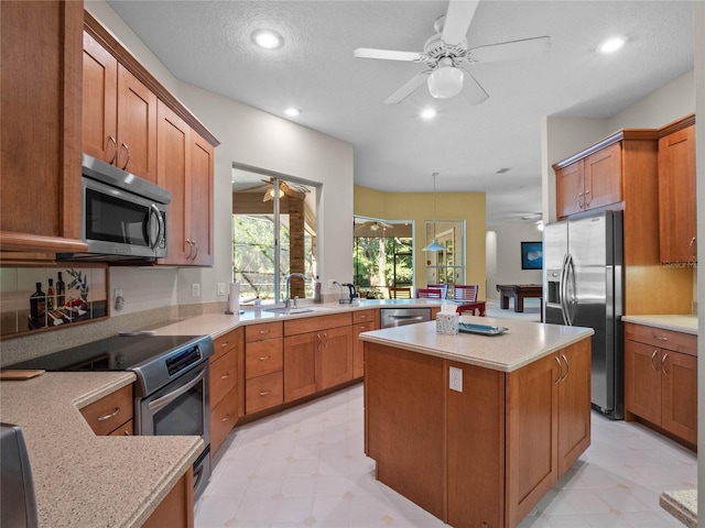 kitchen with a center island, hanging light fixtures, a textured ceiling, appliances with stainless steel finishes, and kitchen peninsula