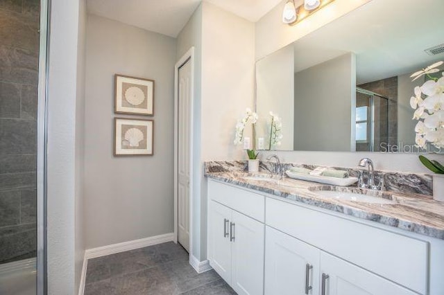 bathroom with tile patterned flooring, vanity, and walk in shower