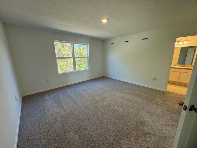 carpeted empty room with a textured ceiling