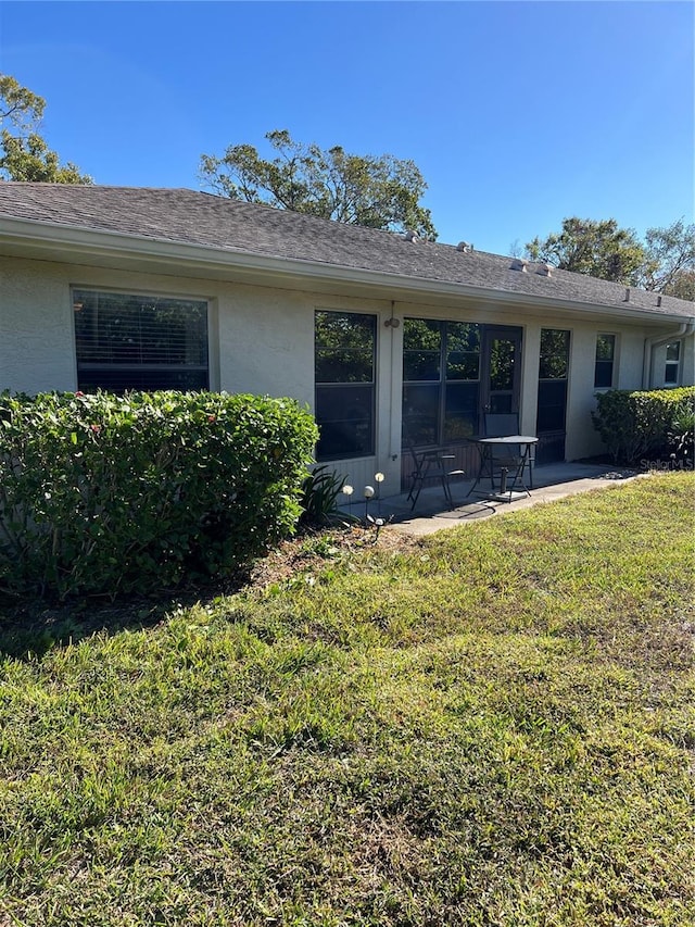 rear view of property with a yard and a patio area